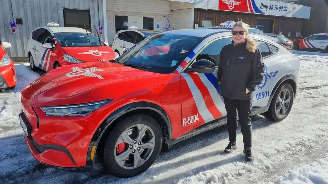 Taxi 1-sjåfør ved bilen på en vinterdag